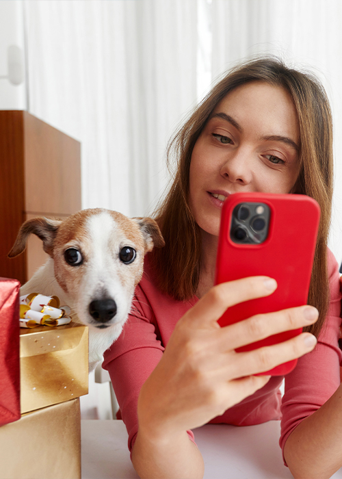 Woman looking at her phone with her dog